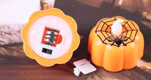Detail of Halloween pumpkin LED candle showing the bottom battery compartment and switch