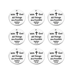 Macro shot of 9 silver stainless steel charms engraved with Matthew 19:26 Bible verse