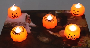 Close-up of LED Halloween pumpkin candle lights with smiling face and spider web patterns