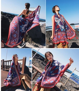Detail of red and blue ethnic pattern shawl draped elegantly in a coastal travel setting