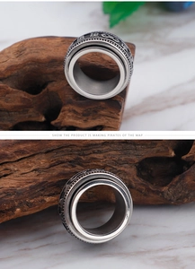 Detail of vintage spinner ring with embossed religious symbols on a rustic wooden base