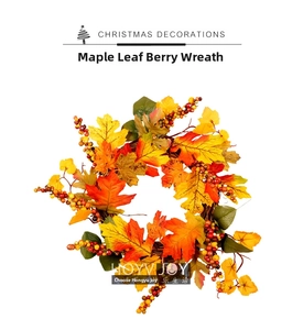 Detail of autumn wreath featuring artificial maple leaves and orange berries on white background