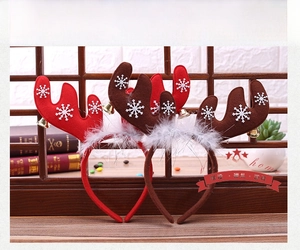 Close-up of Christmas reindeer antler headbands with white snowflake print and metal bells