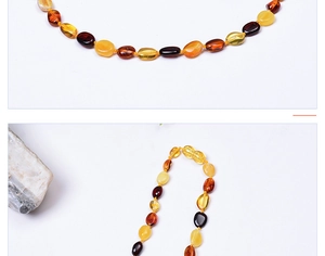 Détail du collier pour bébé en ambre multicolore avec des perles ovales polies