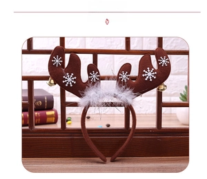 Detail of Christmas reindeer antlers headband with gold bells and white snowflake prints