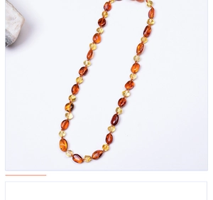 Vue macro de perles d'ambre de la Baltique aux tons chauds dégradés pour collier enfant