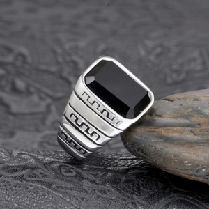 Détail de bague homme en argent avec pierre noire et motif de clé grecque ciselé