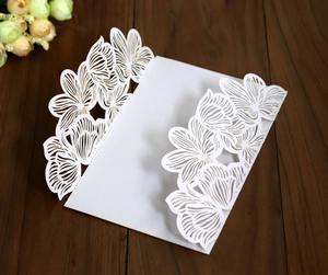 Macro detail of laser-cut white floral hollow pattern on wedding invitation paper