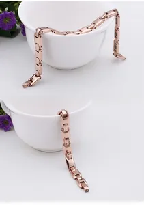 Détail du bracelet magnétique en acier titane or rose avec inserts magnétiques noirs