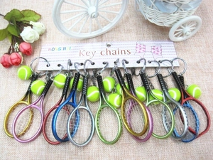 Detailed macro view of tennis racket keychains with miniature balls on branded cards