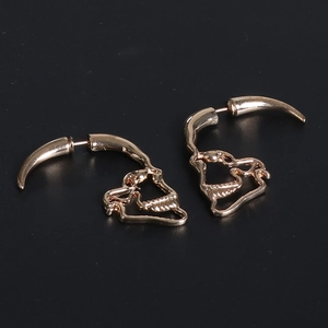 Macro view of gold skull horn earrings with gothic punk style and metallic finish
