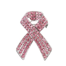 Close-up of pink ribbon brooch with inlaid rhinestones and polished silver metal finish