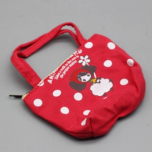 Detailed view of red fabric doll handbag with white polka dots and cartoon patterns