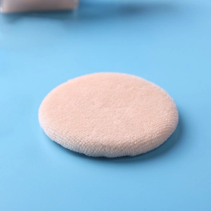 Close-up of soft peach plush cotton powder puff for cosmetics and baby powder