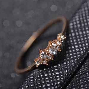 Bague en or rose pour femme ornée de cinq zircons blancs sertis en grappe élégante