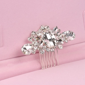 Detailed close-up of bridal hair comb with pearls and rhinestones on a pink velvet base