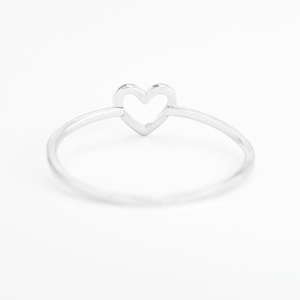 Macro shot of minimalist silver hollow heart ring with high-polish finish on white background