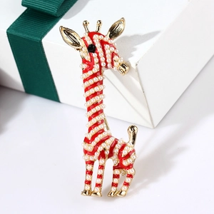 Detailed view of enamel giraffe brooch with red finish and white pearls on a gift box