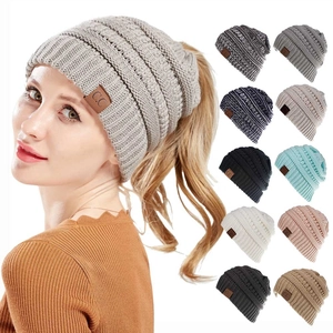 Detail of knit ponytail beanie with top opening and multiple color options guide