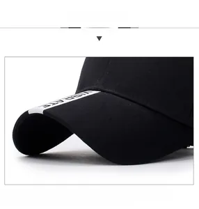 Close-up of black cotton baseball cap brim with white VIBRATE embroidered tape detail