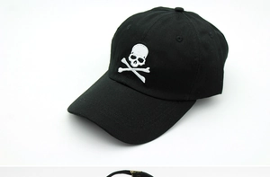 Close-up of white skull embroidery on black cotton twill adjustable baseball cap