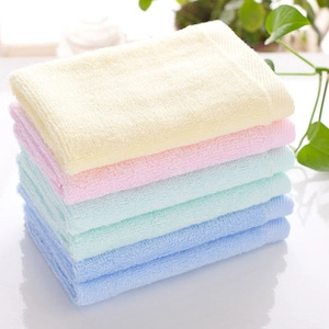 Macro view of stacked square makeup remover cloths in various pastel macaron colors