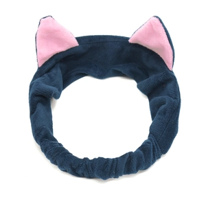 Detail of navy plush headband with pink cat ears for skincare and makeup routines