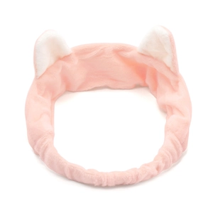 Close-up of a pink plush cat ear headband made of soft fabric for facial skincare routines