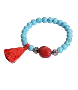 Ethnic beaded bracelet with turquoise stones, red tassel, and vintage silver spacer beads