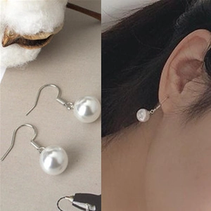 Detail showing silver pearl hook earrings both in flat lay and on ear display