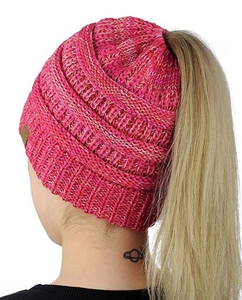 Detail view of the ponytail opening on a mixed fuchsia and white chunky knit beanie