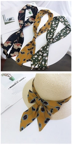 Detailed view of printed silk scarves featuring floral and polka dot patterns on a straw hat
