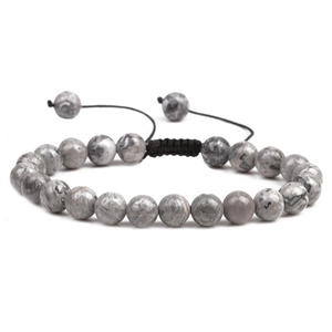 Detail of grey and white snowflake stone beads with black woven adjustable bracelet cord