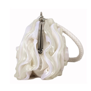 Detailed view of white silk petal layers and silver kiss-lock on elegant evening bag
