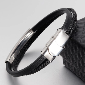 Detail of black double-layered braided leather bracelet with silver metal magnetic buckle