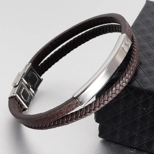Close-up of brown braided leather layer and silver stainless steel clasp on male bracelet