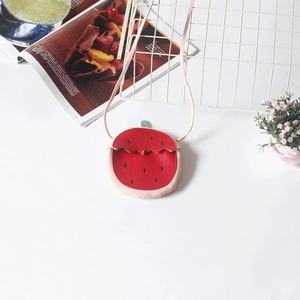Detailed view of kids strawberry crossbody bag with red lychee texture and pink strap