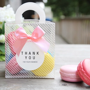 Detailed view of clear gift box with white stripes, pink ribbon bow and thank you sticker