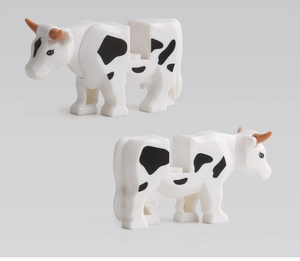 Detailed view of two assembled black and white spotted cow plastic building block figures