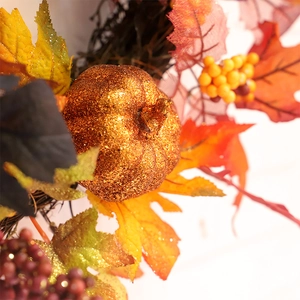 Halloween pumpkin wreath with autumn maple leaves and berries for window decoration