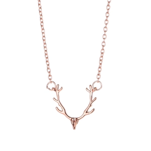 Macro shot of rose gold reindeer antler pendant on a delicate metallic chain