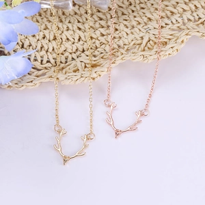 Elegant gold and rose gold reindeer antler necklaces on a rustic woven background