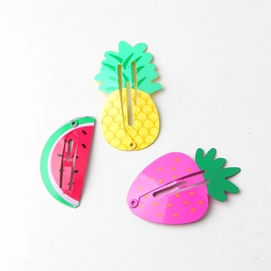 Detailed view of colorful fruit-shaped hair clips featuring pineapple, strawberry, and watermelon