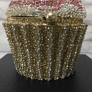 Detailed close-up of cupcake clutch bag with pink and gold rhinestones and spherical clasp