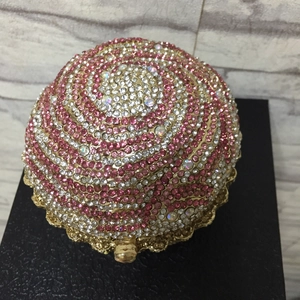 Detailed view of spherical cupcake-shaped evening bag with pink and white rhinestones