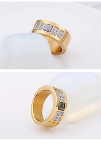 Detail of gold wide band ring with brushed metal texture and zircon inlay accents
