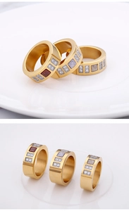 Detailed view of three gold titanium steel rings with colorful stones and zircons