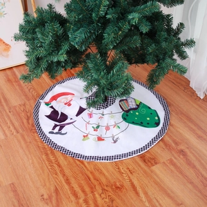 Detail of white Christmas tree skirt with Santa Claus motif and black plaid borders
