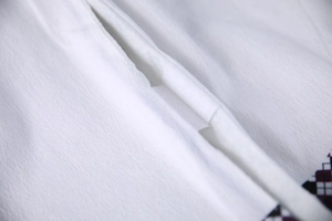 Macro shot of white non-woven Christmas tree skirt showcasing durable stitching details