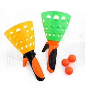 Gros plan sur les lanceurs de balles en plastique colorés avec trois balles oranges.